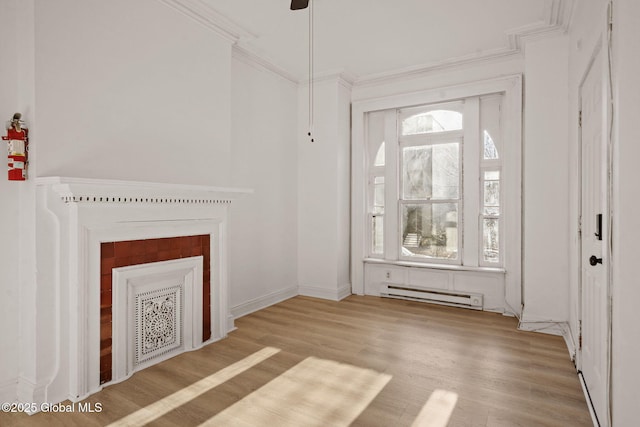 unfurnished living room featuring baseboard heating, ornamental molding, and light hardwood / wood-style flooring