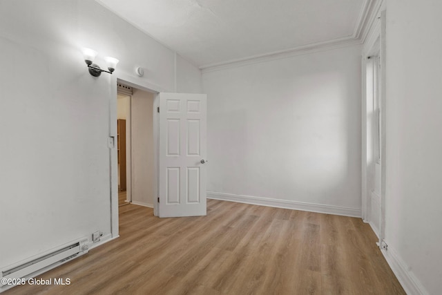 unfurnished room with baseboard heating, light wood-type flooring, and crown molding