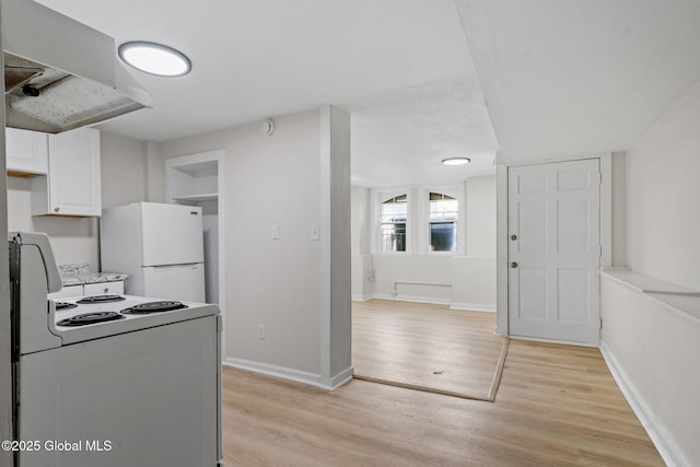 kitchen featuring white appliances, light hardwood / wood-style floors, and white cabinets