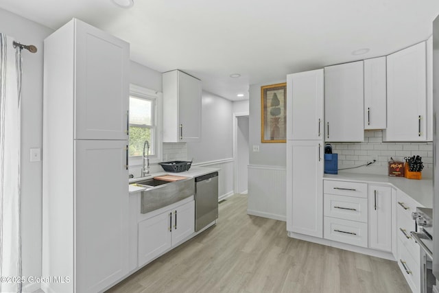 kitchen featuring backsplash, white cabinets, dishwasher, and stove