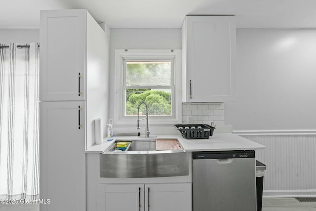 kitchen with white cabinetry, decorative backsplash, dishwasher, and sink