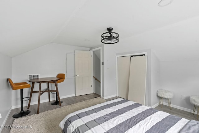 bedroom featuring lofted ceiling, a closet, and hardwood / wood-style floors