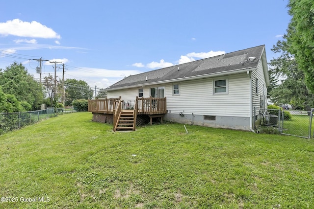 back of property featuring a wooden deck and a yard