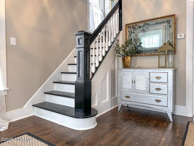 stairway featuring a high ceiling and hardwood / wood-style floors