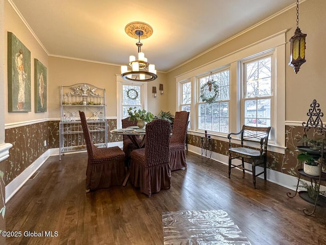 dining room with dark wood-type flooring, a notable chandelier, and crown molding