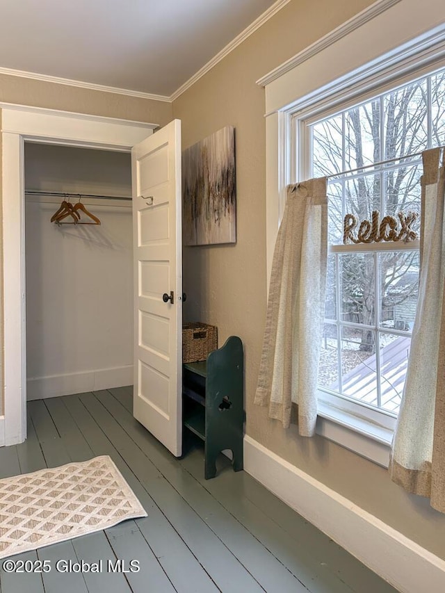 bedroom with a closet, crown molding, and dark wood-type flooring