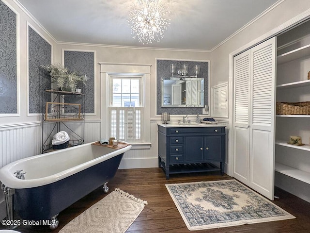 bathroom with hardwood / wood-style flooring, a washtub, vanity, a chandelier, and crown molding