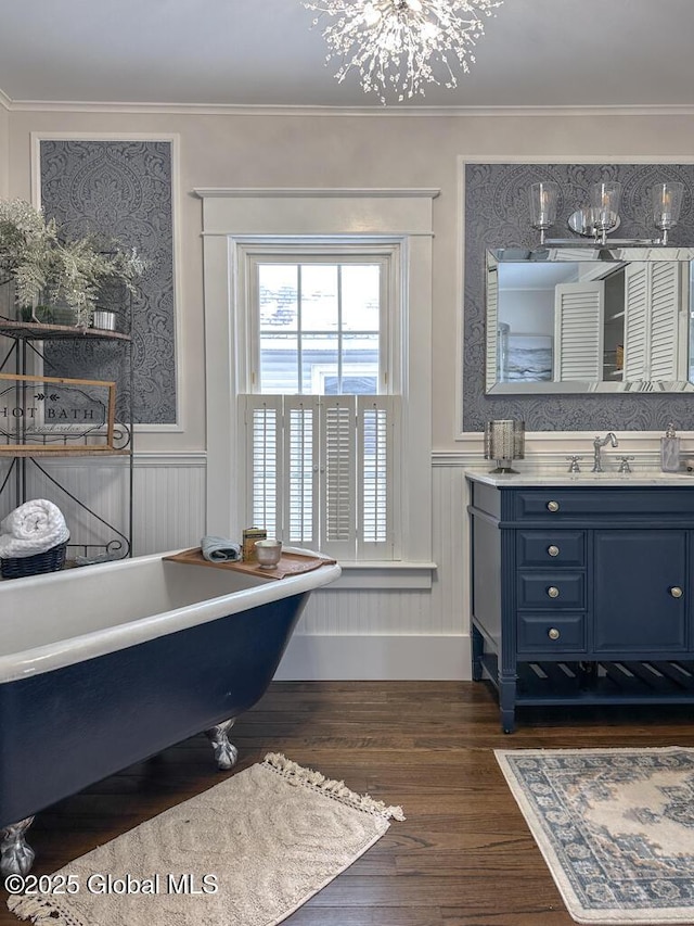 bathroom with ornamental molding, a bathtub, vanity, and hardwood / wood-style flooring