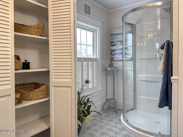 bathroom featuring a shower with shower door and crown molding