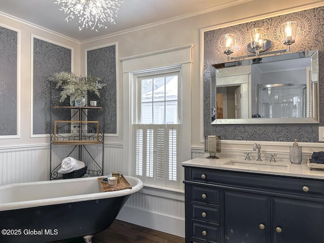 bathroom with plus walk in shower, vanity, ornamental molding, hardwood / wood-style flooring, and an inviting chandelier