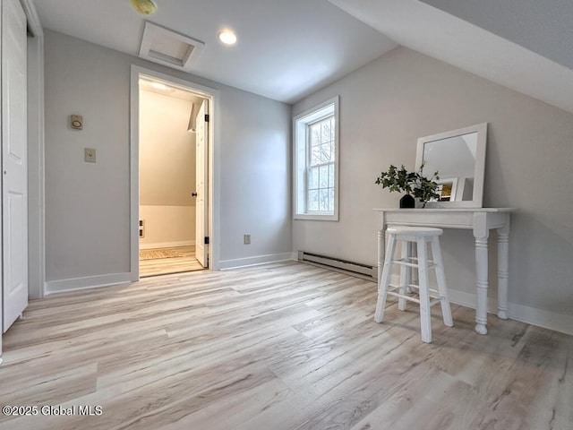 additional living space featuring lofted ceiling, a baseboard radiator, and light hardwood / wood-style flooring