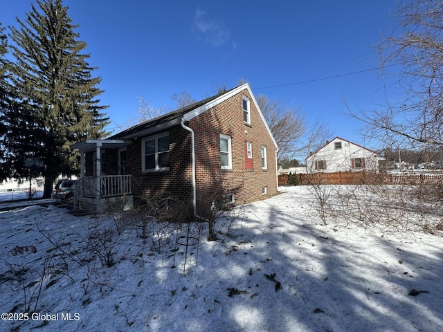 exterior space featuring brick siding and fence