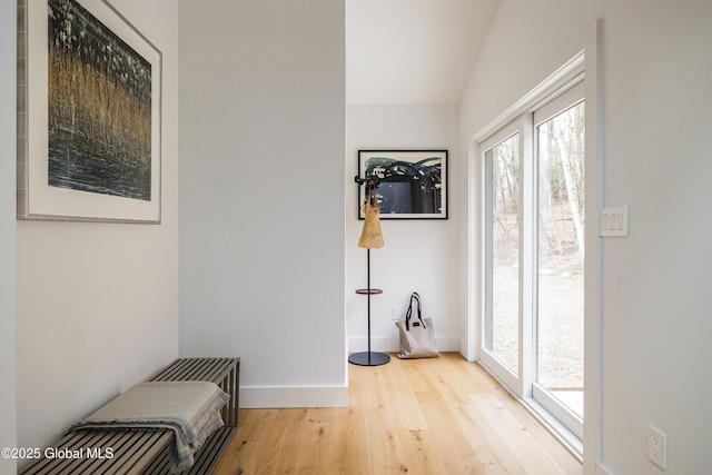 doorway with lofted ceiling and light hardwood / wood-style flooring