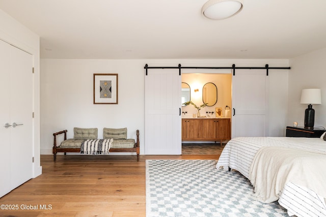 bedroom with wood-type flooring, a closet, and a barn door