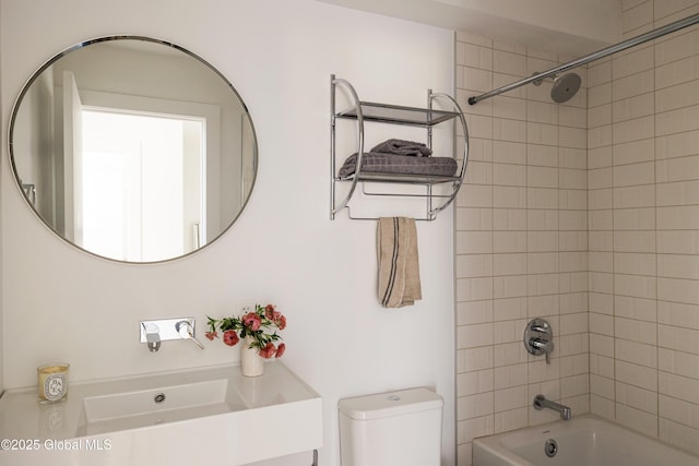 full bathroom featuring sink, toilet, and tiled shower / bath