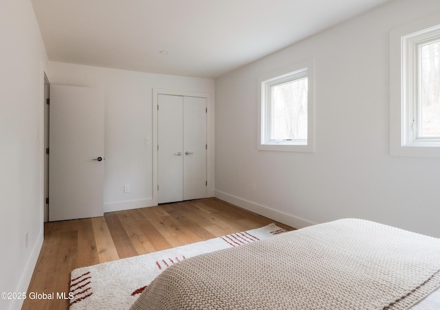 unfurnished bedroom featuring light hardwood / wood-style flooring and a closet