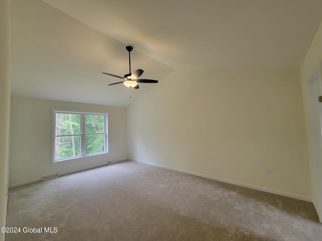 carpeted spare room with ceiling fan and lofted ceiling