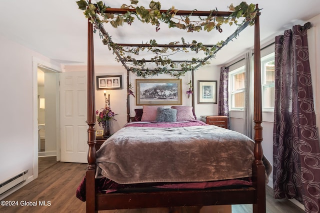 bedroom featuring baseboard heating, baseboards, and wood finished floors