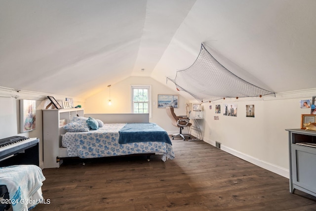 bedroom featuring baseboards, lofted ceiling, and wood finished floors