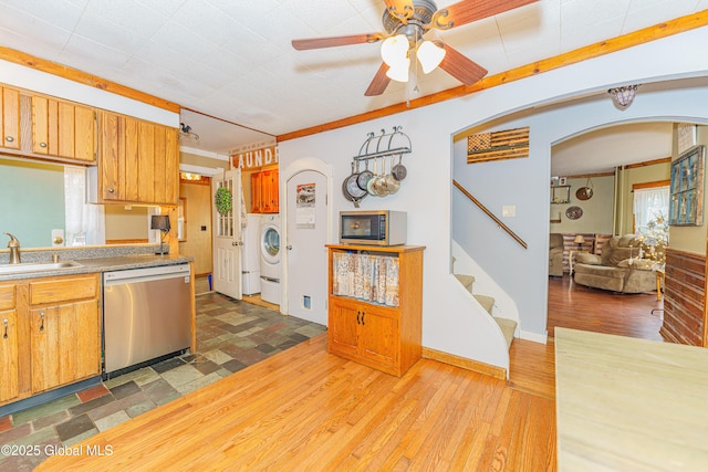 kitchen with stainless steel appliances, washer / dryer, crown molding, ceiling fan, and sink