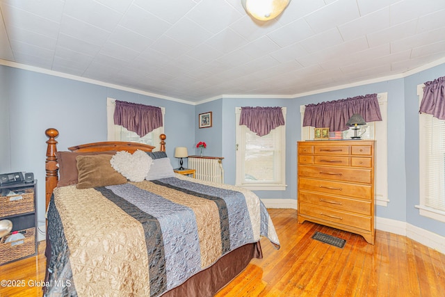 bedroom featuring wood-type flooring and ornamental molding