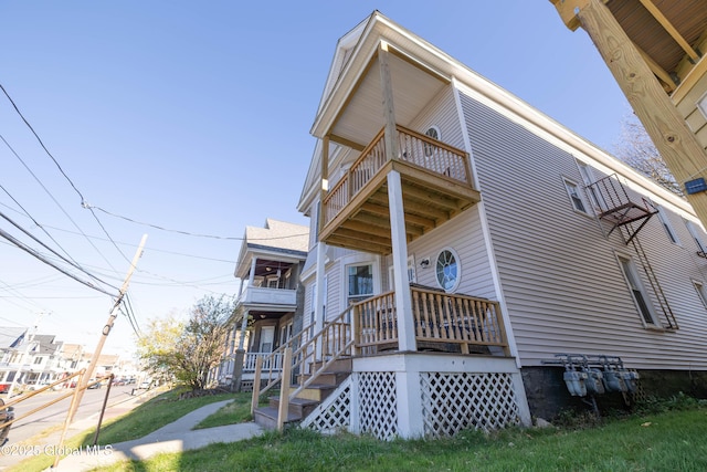 view of side of home with a lawn and a balcony