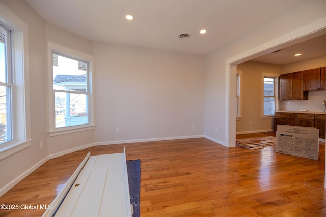 unfurnished dining area with light wood-type flooring and a healthy amount of sunlight