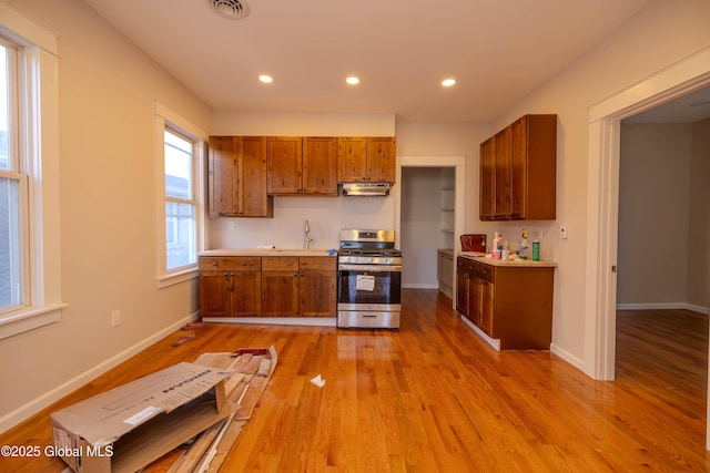 kitchen with light hardwood / wood-style floors and stainless steel range with gas stovetop