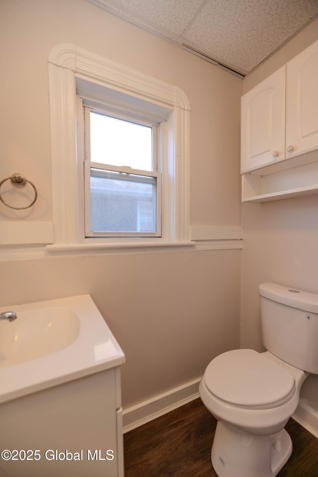 bathroom featuring a paneled ceiling, vanity, toilet, and hardwood / wood-style flooring