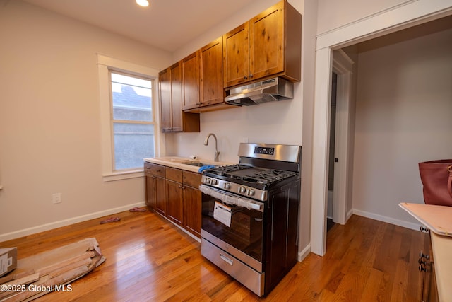 kitchen featuring sink, light hardwood / wood-style floors, and stainless steel gas stove