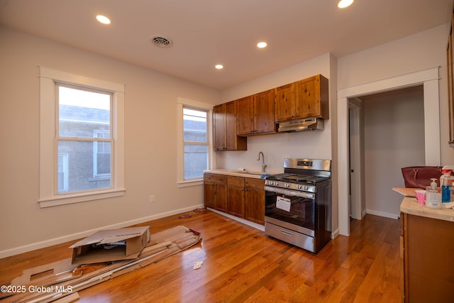 kitchen with gas stove, sink, and light hardwood / wood-style flooring