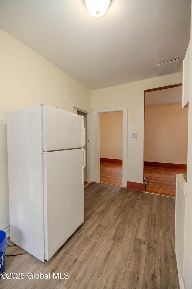 kitchen with white refrigerator and hardwood / wood-style floors