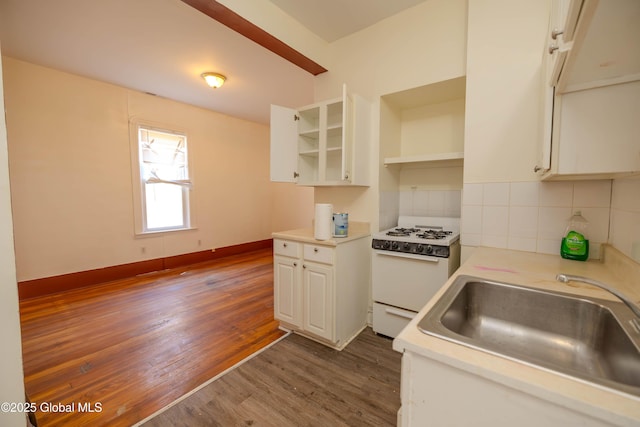 kitchen featuring sink, white cabinets, decorative backsplash, gas range gas stove, and dark hardwood / wood-style flooring