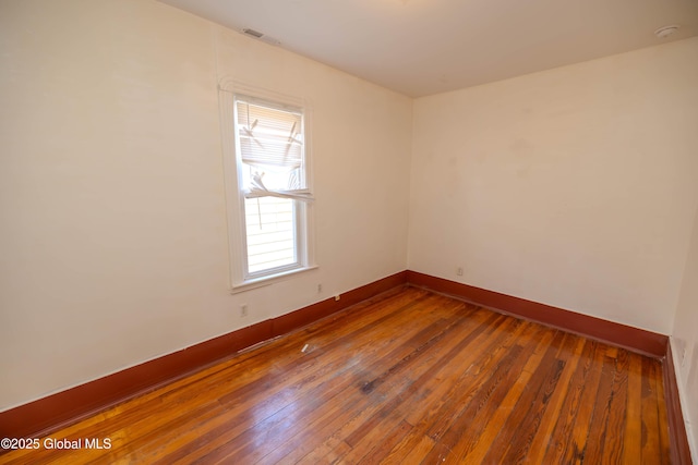 spare room featuring hardwood / wood-style floors and plenty of natural light