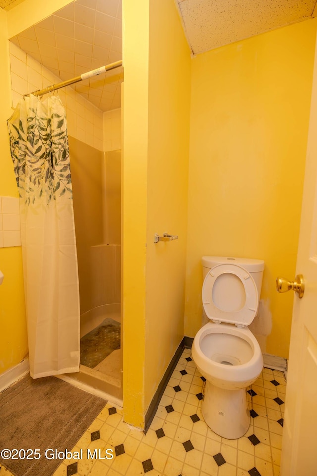 bathroom featuring toilet and a shower with shower curtain