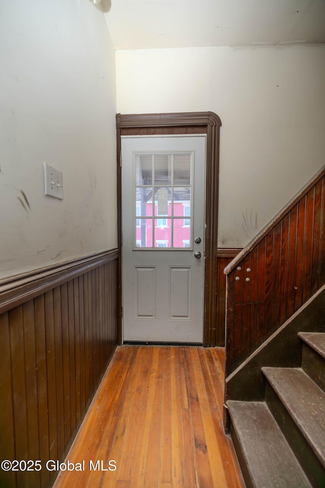 entryway with wooden walls and light wood-type flooring