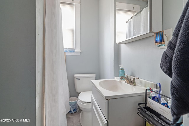 bathroom featuring vanity, tile patterned flooring, and toilet