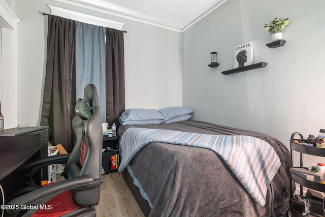 bedroom featuring crown molding and wood-type flooring