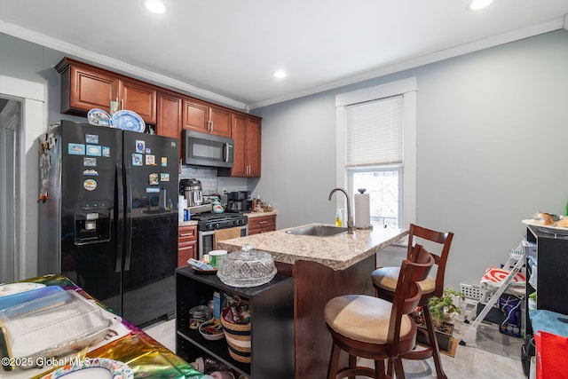 kitchen featuring sink, appliances with stainless steel finishes, backsplash, a kitchen breakfast bar, and ornamental molding