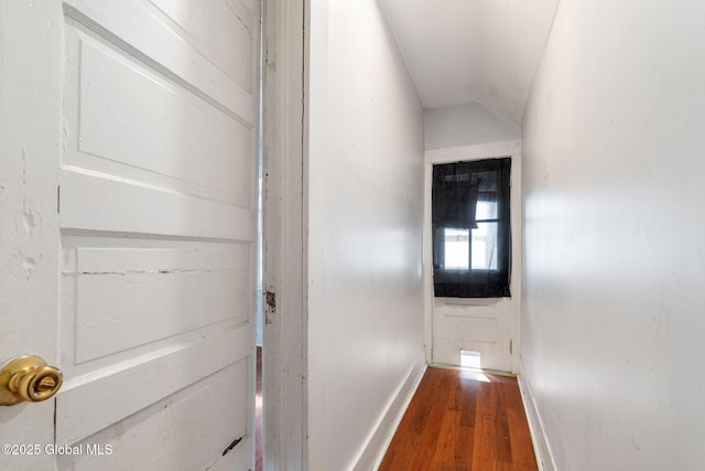 hallway with vaulted ceiling and hardwood / wood-style floors