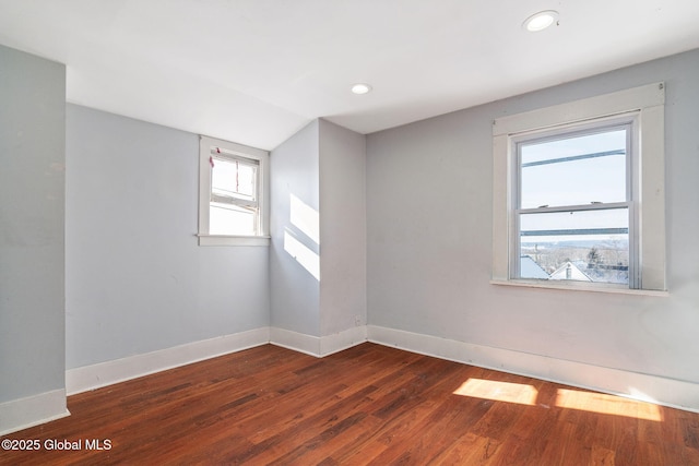 unfurnished room featuring dark hardwood / wood-style flooring and vaulted ceiling