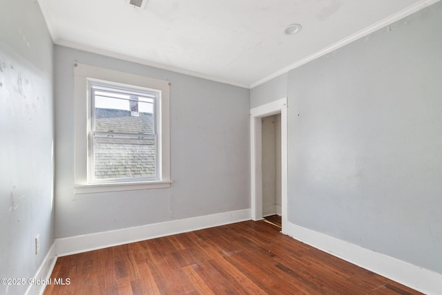 empty room featuring dark hardwood / wood-style flooring and crown molding