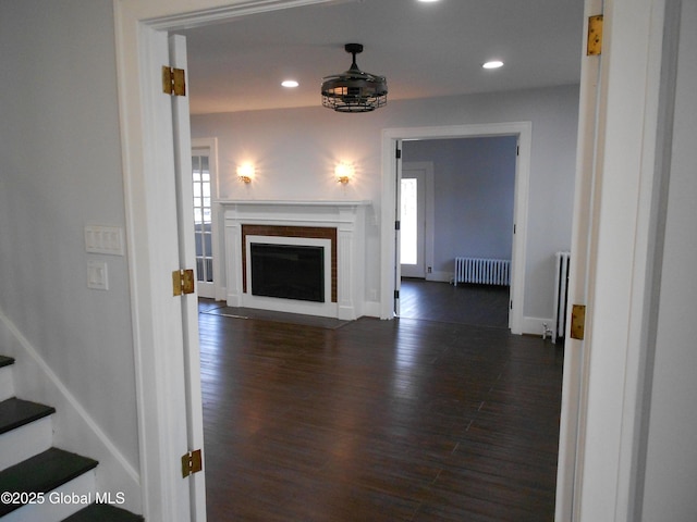 living room with dark wood-type flooring and radiator