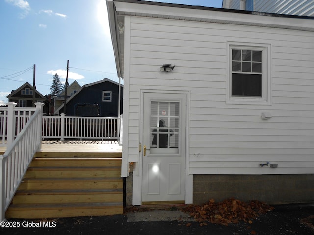 view of exterior entry featuring a wooden deck