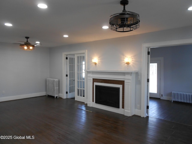 unfurnished living room featuring radiator, ceiling fan, and dark hardwood / wood-style floors