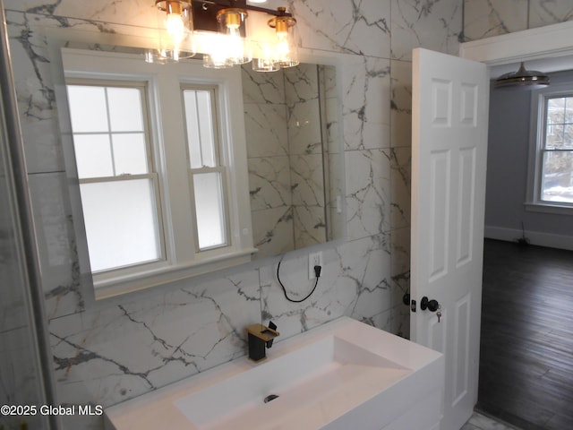 bathroom featuring plenty of natural light, a notable chandelier, and vanity