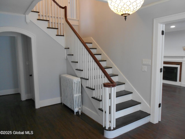 stairway with wood-type flooring and radiator heating unit