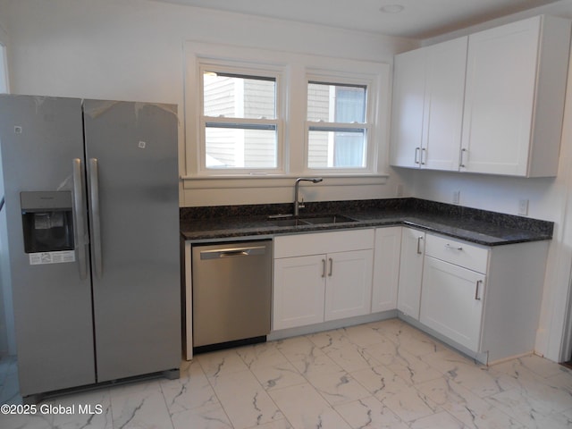 kitchen with appliances with stainless steel finishes, white cabinetry, and sink