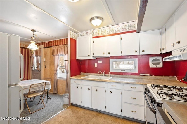 kitchen featuring hanging light fixtures, white cabinetry, sink, and white appliances