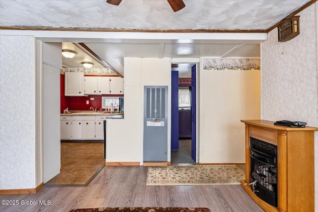 kitchen featuring ceiling fan, light hardwood / wood-style flooring, sink, and white cabinets